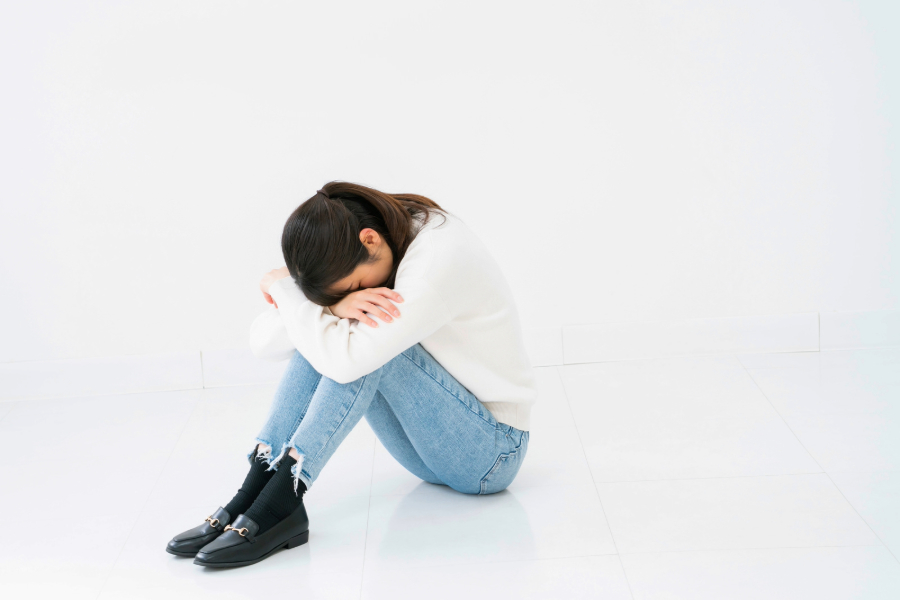 世間体を気にしてふさぎ込む不安いっぱいの母のイメージ