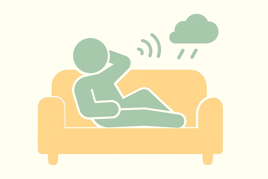 活動量が減ってお腹が空かない不登校の子どもの様子を表したピクトグラムのイラスト。ソファで横になり、スッキリしない気分で体を休めている姿のイメージ。
